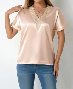 Close-up of elegant champagne satin blouse featuring detailed lace V-neck trim
