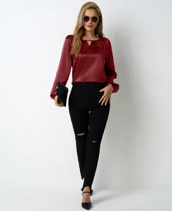 Weibliches Model trägt eine weinrote Satinbluse mit plissiertem Ausschnitt und langen Ärmeln