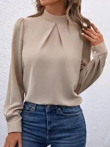 Detailaufnahme einer beigen Satinbluse mit plissiertem Stehkragen und langen Ärmeln