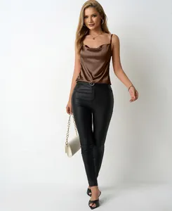 View of a model wearing the brown satin cowl neck tank top with slim spaghetti straps