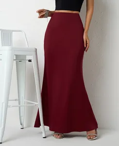 Elegant burgundy satin maxi skirt with a fishtail hem shown on a model in a minimalist setting.