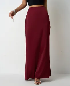 Detailed view of an elegant burgundy satin maxi skirt with high-waisted tailoring.