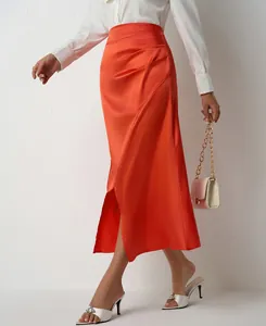 Close-up of vibrant orange satin pleated skirt with side slit detail
