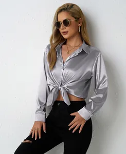 Detail view of a silver satin V-neck shirt with a front knot waist design for women.