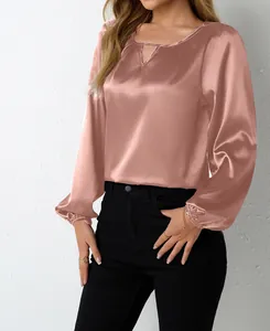 Nahaufnahme einer eleganten roségoldenen Satinbluse mit schickem V-Ausschnitt-Ausschnitt
