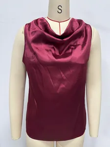 Detailed view of burgundy sleeveless satin blouse with elegant cowl neck on mannequin