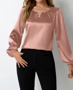Nahaufnahme einer roségoldenen Satinbluse mit elegantem plissiertem Schlüsselloch-Ausschnitt