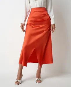 Detail of elegant high waist orange satin midi skirt with side slit and pleated design