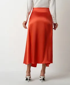 Back view of high waisted orange satin midi skirt with elegant sheen and slit detail