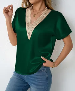 Detailed view of dark green satin V-neck blouse with elegant beige lace trim