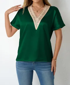 Detail of a dark green satin blouse featuring an intricate lace-trimmed V-neckline