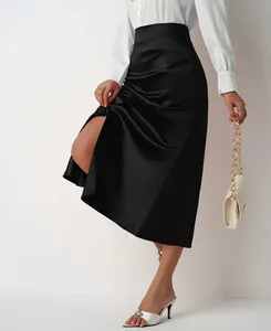 Close-up of elegant high-waisted black satin midi skirt featuring a sexy side slit