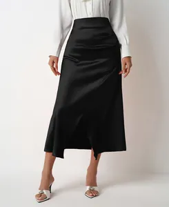 Detail view of a high-waisted black satin midi skirt featuring an elegant side slit
