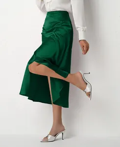 Detailed view of green satin midi skirt showing side split and fabric texture