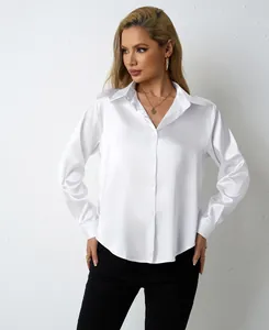 Elegant white satin long-sleeved blouse shown on a model against a textured wall