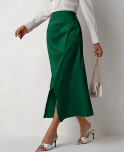 Detail view of a green high-waisted satin midi skirt with side slit and ruched detail