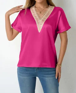 Detailed macro view showing the elegant lace trim and satin texture of the pink V-neck top.
