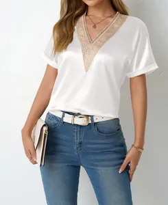 Detailed view of the elegant lace V-neck and smooth satin fabric of the white top