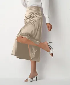 Detail of high-waisted satin midi skirt with elegant front slit in champagne gold