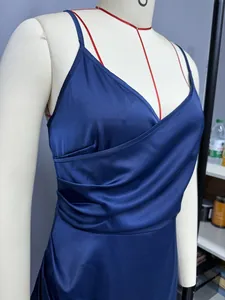 Close-up of navy blue satin slip dress showing elegant wrap and pleated detail.