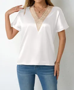 Close-up of white satin V-neck blouse with elegant gold lace trim details for women