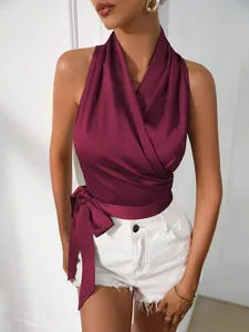 Detail van bordeauxrode satijnen haltertop met een elegante zijstrik en een modieus overslagontwerp