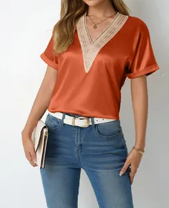 Detail view of women's orange satin V-neck T-shirt featuring elegant beige lace trim