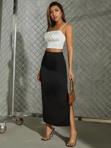 Detail shot of black satin midi skirt with a side slit and elegant high-waisted cut.