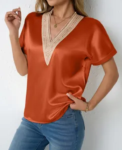 Detail view of a vibrant orange V-neck satin blouse with delicate lace trim for women
