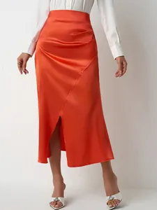 Elegant high-waisted orange satin midi skirt with side slit and pleated detail.
