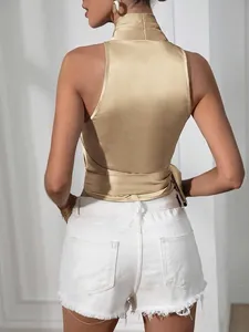 Gedetailleerd achteraanzicht van een elegante gouden satijnen haltertop met striksluiting