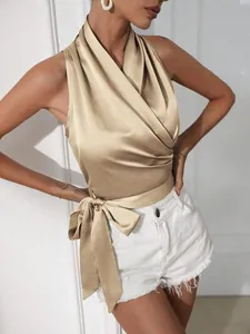 Detail van de champagne satijnen halter-wikkelkraagtop met elegante strik aan de zijkant