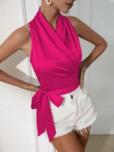 Detail van fuchsia satijnen halter-wikkelshirt met zijwaartse strik voor zomerstijl dames.