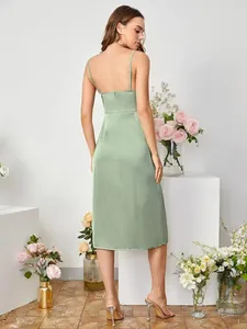 Back view of elegant sage green satin slip dress with slit in a floral studio setting