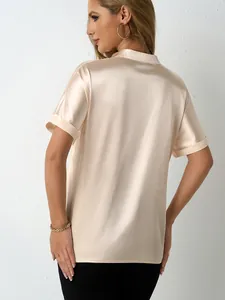 Vista posteriore di un'elegante camicetta in raso champagne con colletto alla coreana.