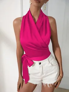 Detail van fuchsia satijnen haltertop met een elegant strikontwerp in de taille