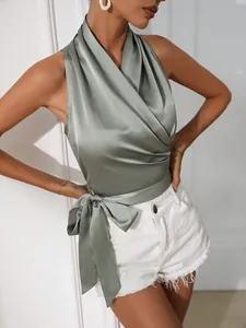 Gedetailleerd overzicht van een elegante saliegroene satijnen haltertop met strik