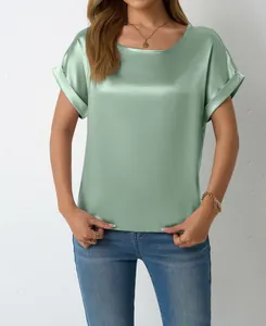Dettaglio ravvicinato di una camicetta di raso verde menta a maniche corte da donna, seta premium.