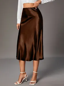 High-waisted brown satin midi skirt with elegant silk-like glossy finish on model