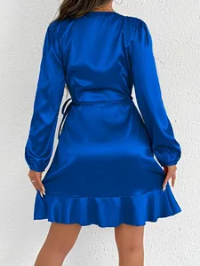 Detailed back view of an elegant royal blue satin long sleeve dress with a ruffle hemline
