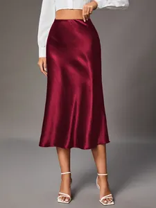 High-waisted burgundy satin midi skirt with a silky glossy finish and A-line silhouette.