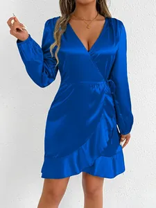 Detail view of a royal blue satin long-sleeved wrap dress featuring elegant ruffle hem