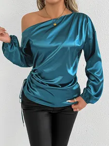 Detail of elegant blue satin long sleeve blouse with off-shoulder design and ruched side