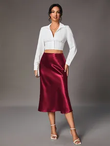 Elegant burgundy satin midi skirt paired with a white cropped shirt detail shot