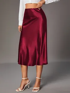 Elegant high-waisted burgundy satin midi skirt with a glossy silk-like smooth finish