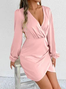 Close-up of pink satin long sleeve wrap dress with elegant pleated waist detail