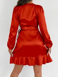 Back view detail of a vibrant red satin long-sleeve dress with ruffle hem