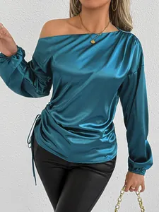 Detail of blue satin long sleeve blouse with elegant side-tie and off-the-shoulder design
