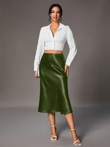 Elegant dark green satin midi skirt paired with a white cropped long-sleeve shirt.