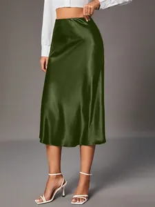 Elegant dark green satin midi skirt showing smooth silk-like fabric and graceful drape.